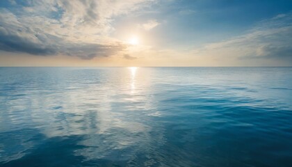 Obraz premium Closeup surface of calm ocean blue sea water with sunshine and clouds behind. Abstract Background Texture.