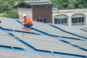 Worker Technicians are working to construct solar panels system on roof. Installing solar photovoltaic panel system. Men technicians walking on roof structure to check photovoltaic solar modules.