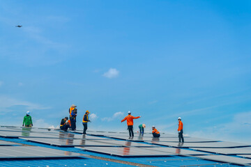 Worker Technicians are working to construct solar panels system on roof. Installing solar...