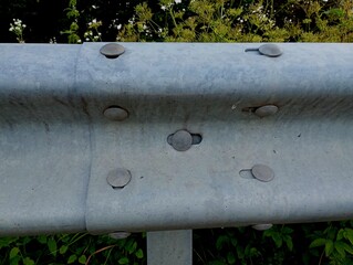 Connection with the help of large rivets of two elements of a gray metal iron bumper.