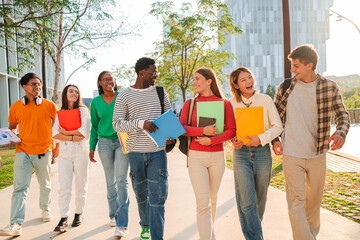 Big group of international classmates walking and talking together on the university campus. Happy...