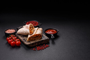 Delicious juicy roll or shawarma with chicken, tomatoes, salad and sauce