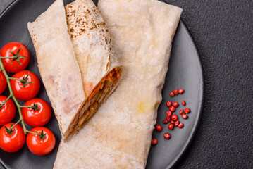 Delicious juicy roll or shawarma with chicken, tomatoes, salad and sauce
