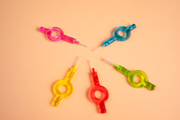 Many Colorful Interdental, Dental Brush Angle, Toothpick for Teeth Cleaning, Braces On Yellow Peach Background. Top View Dentistry, Oral Health Hygiene. Teeth Cleaner. Flossing Oral Brush, Horizontal