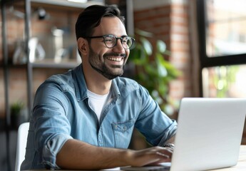 Fototapeta premium smiling man and woman in casual attire are sitting at an office desk with laptops, working together on digital marketing projects