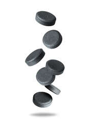 Levitation of activated charcoal pills in the air isolated on a white background