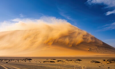 A dust storm is forming on top of the dune, blowing sand and debris across its surface. The wind can be seen swirling around it as if trying to quell its impact.