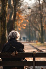 Fototapeta premium Reflective Man Sitting on Park Bench in Winter Setting - Contemplation, Solitude, Seasonal Outdoors