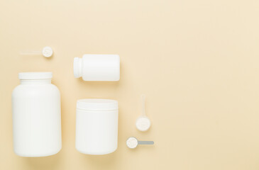 Jars with protein powder on color background, top view. Sports nutrition concept