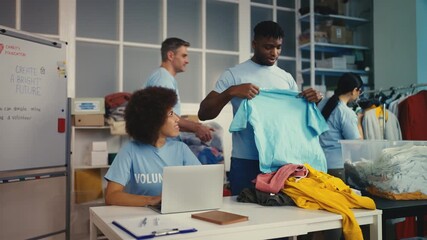 Volunteers sorting clothes at nonprofit charity organization, packing into boxes - Powered by Adobe