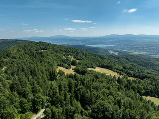 Fototapeta premium Stunning Aerial Drone View of Summer Green Forests in the Beskid Mountains, Bielsko Biala, Magurka Wilkowicka, Hills landscape Capturing the Beauty and Serenity of Lush Greenery and Rolling Hills