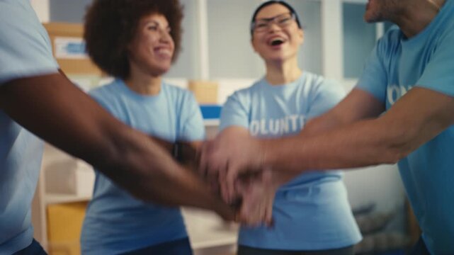 Diverse team of volunteers stacking hands, ready to help people, charity