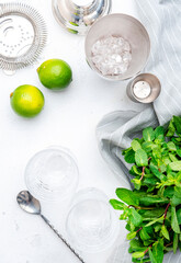 Ingredients for making alcoholic summer cocktail drink and bar tools, white background, top view