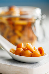 Pickled nameko mushrooms.Traditional japanese mushrooms in ceramic spoon on white table.