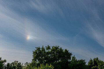 atmospheric optical phenomena. Iridescent clouds with blue sky