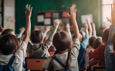 Enfants, élèves de primaire qui lèvent la main dans une salle de classe. Camarade de classe, écoliers en plein cours. Interroger, professeur, leçons. Rentrée scolaire, septembre. 