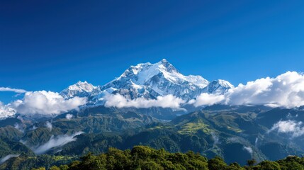 Fototapeta premium The mountain range is covered in snow and the sky is clear and blue. The clouds are scattered throughout the sky, giving the scene a peaceful and serene atmosphere