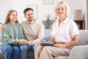 Obraz premium Female psychologist with clipboard and happy couple sitting in office