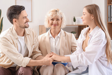 Obraz premium Female psychologist with young couple holding hands in office