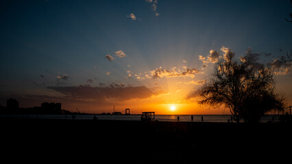 A Stunning Sunset Displaying Vibrant Colors Over the Horizon, Right by the Beautiful Beach