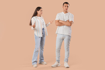 Young couple quarreling on beige background