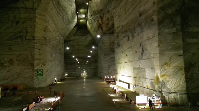 Aerial video inside a giant salt mine in the carpathian mountains of Romania. The vast mine of Salina Slanic Prahova seen from a drone. Flying within an old rock salt quarry. Tourist attraction.
