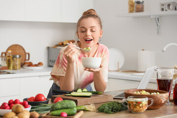Young woman eating tasty okroshka in kitchen
