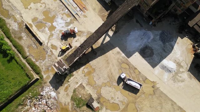 Aerial footage of halite or rock salt being loaded by a wheel front loader on a bulk cargo tipper truck. Drone shot of salt being poured in an industrial truck and weighed at a salt mine. Industrial

