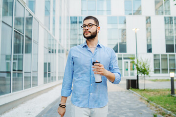 Young caucasian businessman going to work to modern business building