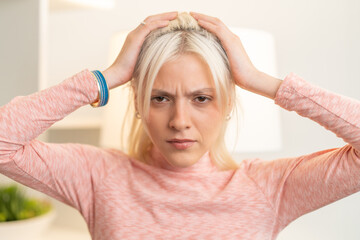 Young woman pulling her hair feeling stressed and frustrated