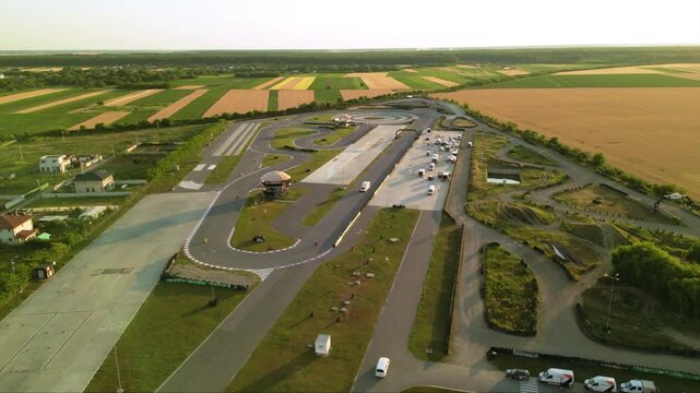 Aerial drone footage of a racing circuit and defensive driving course facility. High angle shot of asphalt and offroad sections of a drifting and racing driving training facility. stunt driver concept