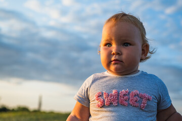 Adventurous Baby Strolling Through a Field at Sunset in the Evening Glow