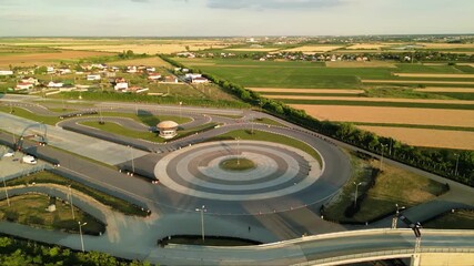 Aerial drone footage of a racing circuit and defensive driving course facility. High angle shot of asphalt and offroad sections of a drifting and racing driving training facility. stunt driver concept