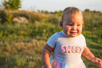 Adventurous Baby Strolling Through a Field at Sunset in the Evening Glow