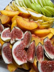 Summer food. Plate with juicy fruit slices. Figs, peaches, apples, pears. 