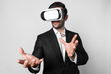 Professional business man holding something while using VR glasses to enter metaverse. Project manager looking at data analysis while wearing suit and virtual reality goggles. Innovation. Deviation.
