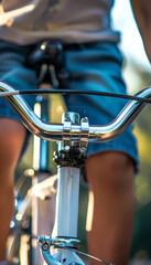 Obraz premium Close-Up Detail of Child's Hands Gripping Bicycle Handlebars in Outdoor Setting