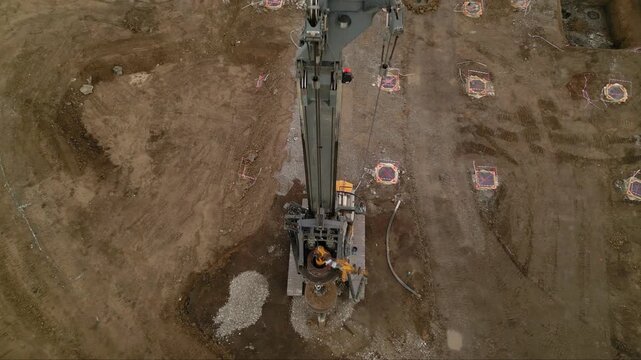 Aerial shot of shale gas drilling rig in a rural field in Romania. Fracking drill seen from above in the middle of a crop field. Drone footage of Hydraulic fracturing construction site.
