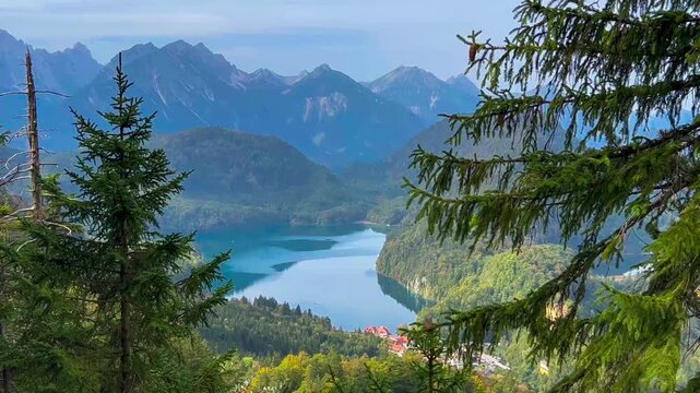 Landscape lake in mountains among pine forest in vicinity of the castle Neuschwanstein castle on Alps background, Bavaria, Germany, Europe. Autumn landscape with castle and lake in mountains 