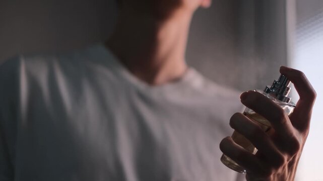 A man applies perfume before leaving the house, close-up