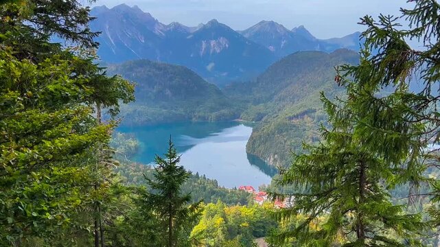 Landscape lake in mountains among pine forest in vicinity of the castle Neuschwanstein castle on Alps background, Bavaria, Germany, Europe. Autumn landscape with castle and lake in mountains 