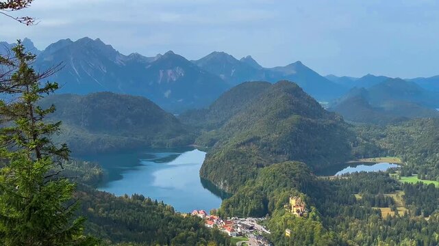 Landscape lake in mountains among pine forest in vicinity of the castle Neuschwanstein castle on Alps background, Bavaria, Germany, Europe. Autumn landscape with castle and lake in mountains 