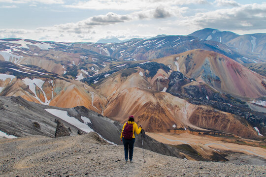 A woman enjoying the panoramic and breathtaking view of the colourful cliffs and peaks at Landmannalaugar in Iceland