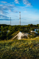 Obraz premium Telecommunications Towers Stand Tall Over Green Landscape at Dusk in Rural Area
