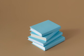 Stack of blue books on a brown background with soft shadow, copy space. Book Lovers Day concept