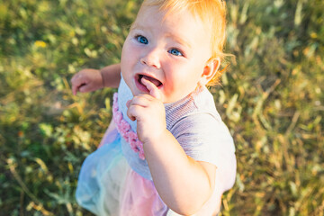 Happy Baby Enjoying Sunshine While Playing Outdoors in a Green Field