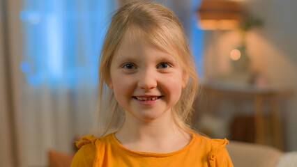 Portrait little Caucasian girl child daughter schoolgirl happy joyful toothy smiling female pupil school kid orphan carefree funny toddler baby face purity smile laugh home children custody adoption