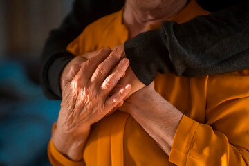 Man support his old grandmother, holds her hands.