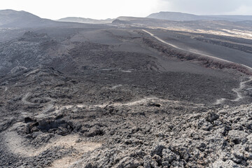 Red volcanic debris from the explosion crater of Garrayto lies on the surface of the hills that divide Lake, Garrayto, Djibouti