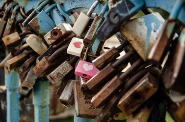 Love locks traditionally hung on the bridge by lovers and newlyweds, close-up.